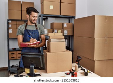 Young Hispanic Man Business Worker Writing On Notebook At Storehouse