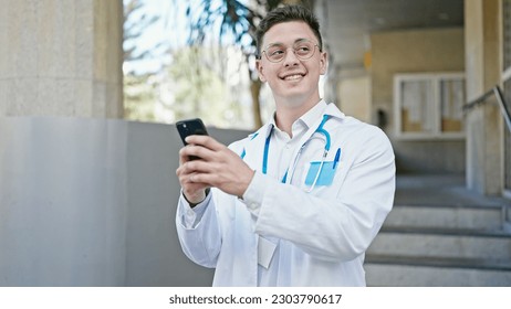 Young hispanic man doctor smiling confident using smartphone at hospital - Powered by Shutterstock