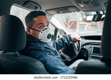 young hispanic man is a driver of the car in a protective mask. prevent the spread of coronavirus. young hispanic taxi driver wearing a protective mask . quarantine.  covid 19. coronavirus.