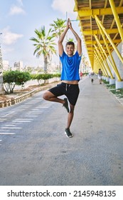 Young Hispanic Man Exercising Doing Tree Pose Outdoors