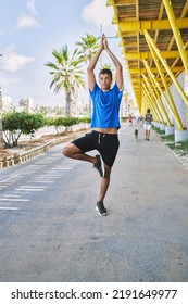 Young Hispanic Man Exercising Doing Tree Pose Outdoors