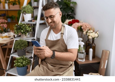 Young hispanic man florist smiling confident using smartphone at flower shop - Powered by Shutterstock