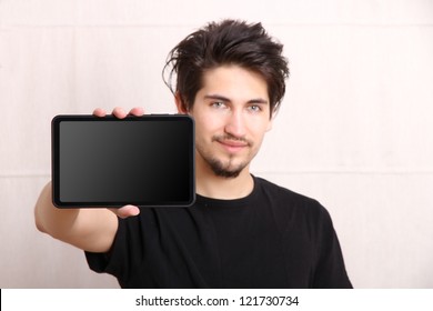 A young hispanic man holding a Tablet PC.