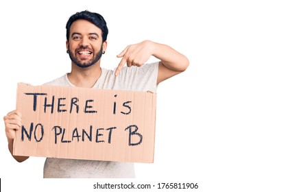 Young Hispanic Man Holding There Is No Planet B Banner Smiling Happy Pointing With Hand And Finger 