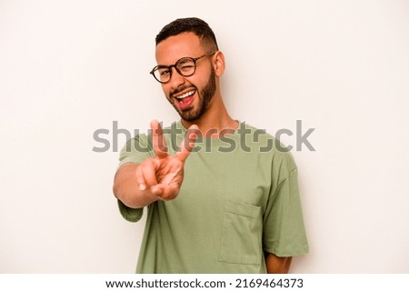 Young hispanic man isolated on white background showing number two with fingers.