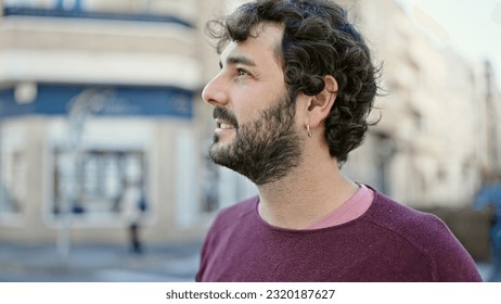 Young hispanic man looking to the side with serious expression at street