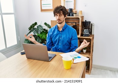 Young Hispanic Man Meditating Doing Yoga Exercise At Office