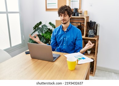 Young Hispanic Man Meditating Doing Yoga Exercise At Office