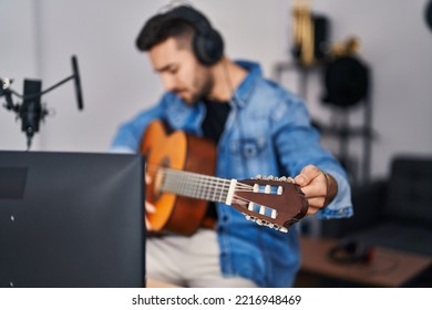 Young Hispanic Man Playing Classical Guitar At Music Studio