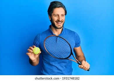 Young Hispanic Man Playing Tennis Holding Racket And Ball Smiling And Laughing Hard Out Loud Because Funny Crazy Joke. 