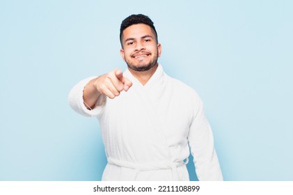 Young Hispanic Man Pointing Or Showing And Wearing A Bathrobe