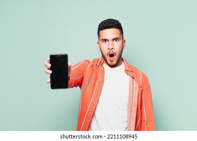 Young Hispanic Man Scared Expression And Holding A Mobile Phone