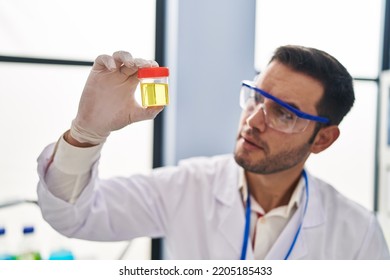 Young Hispanic Man Scientist Looking Urine Test Tube At Laboratory