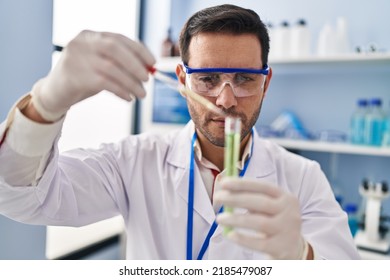 Young hispanic man scientist measuring liquid at laboratory - Powered by Shutterstock