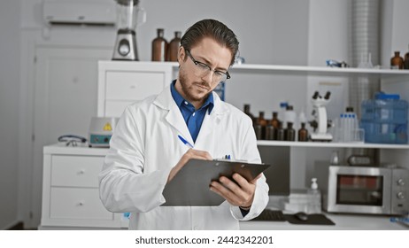 Young hispanic man scientist writing report standing at laboratory - Powered by Shutterstock