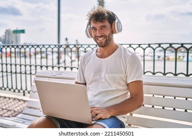 Young Hispanic Man Smiling Confident Using Laptop At Seaside