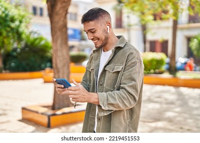 Young hispanic man smiling confident playing video game at park