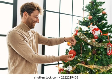 Young hispanic man smiling confident decorating christmas tree at home - Powered by Shutterstock