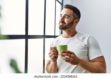 Young hispanic man smiling confident drinking coffee at home - Powered by Shutterstock