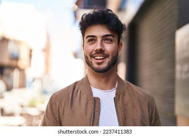 Young hispanic man smiling confident looking to the side at street - Powered by Shutterstock