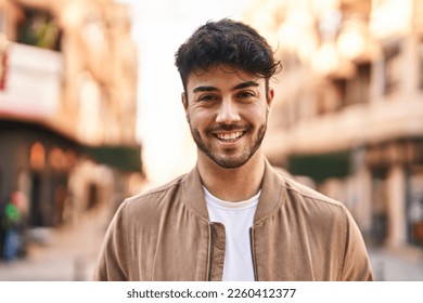Young hispanic man smiling confident standing at street - Shutterstock ID 2260412377