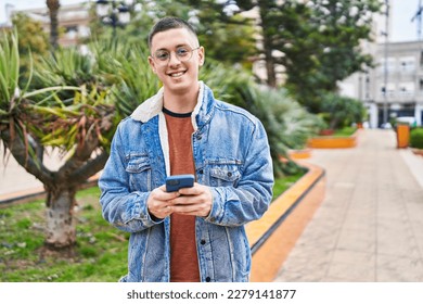 Young hispanic man smiling confident using smartphone at park - Powered by Shutterstock