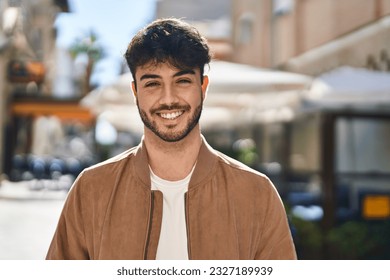 Young hispanic man smiling confident standing at street - Shutterstock ID 2327189939