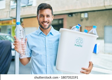 Young Hispanic Man Smiling Happy Recycling. Holding Full Bin Of Plastic Bottle At Street Of City.