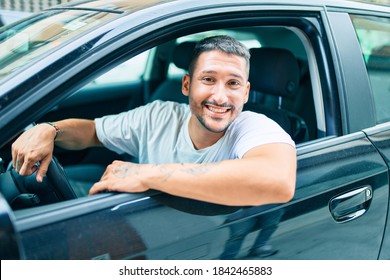 Young Hispanic Man Smiling Happy Driving Car.