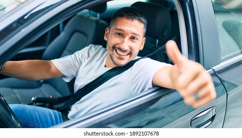 Young Hispanic Man Smiling Happy Doing Ok Sign Driving Car.