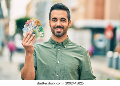 Young Hispanic Man Smiling Happy Holding Australian Dollars At The City.