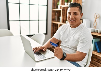 Young Hispanic Man Smiling Happy Using Laptop Sitting On The Table At Home.