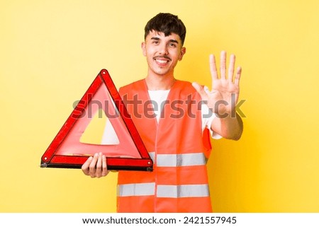 young hispanic man smiling and looking friendly, showing number five. emergency car triangle