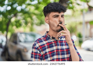 Young hispanic man smoking at street - Powered by Shutterstock