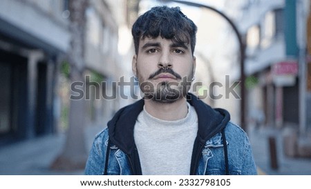 Young hispanic man standing with serious expression at street Foto stock © 