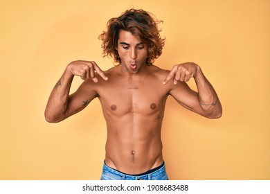 Young Hispanic Man Standing Shirtless Pointing Down With Fingers Showing Advertisement, Surprised Face And Open Mouth 