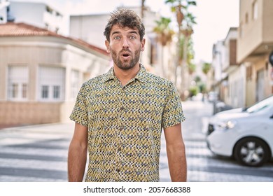 Young Hispanic Man Standing At The Street Scared And Amazed With Open Mouth For Surprise, Disbelief Face 