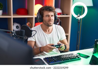 Young Hispanic Man Streamer Playing Video Game Using Joystick At Music Studio