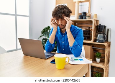 Young Hispanic Man Stressed Working At Office