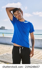 Young Hispanic Man Stretching Neck Muscles Outdoors