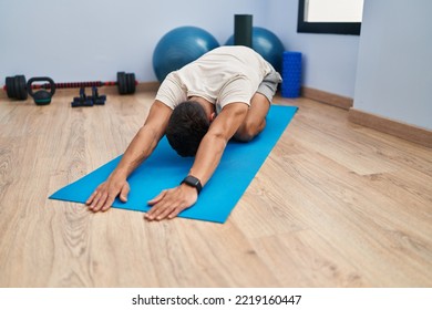 Young hispanic man stretching at sport center - Powered by Shutterstock