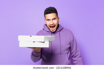 Young Hispanic Man Surprised Expression And Holding Take Away Pizzas