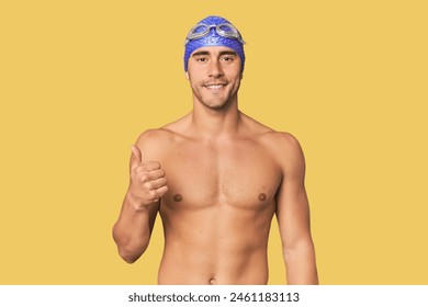 Young Hispanic man with swim gear smiling and raising thumb up - Powered by Shutterstock