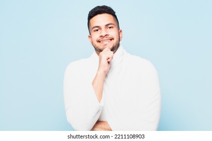 Young Hispanic Man Thinking Expression And Wearing A Bathrobe