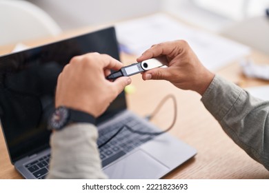 Young hispanic man using crypto cold wallet at office