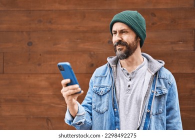 Young hispanic man using smartphone looking positive and happy standing and smiling with a confident smile showing teeth  - Powered by Shutterstock