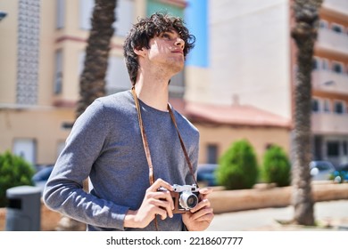 Young Hispanic Man Using Vintage Camera At Park