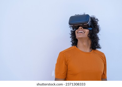 young hispanic man with virtual reality glasses on a white background - Powered by Shutterstock