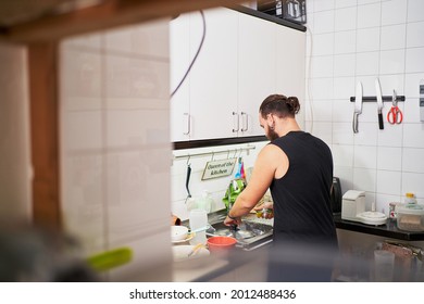 Young Hispanic Man Washing Dishes. Everyday Chores