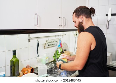 Young Hispanic Man Washing Dishes. Everyday Chores